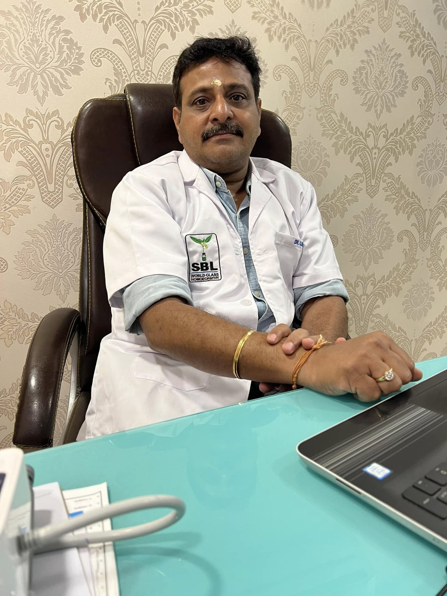 Dr. G. Nirmal seated in his consultation room